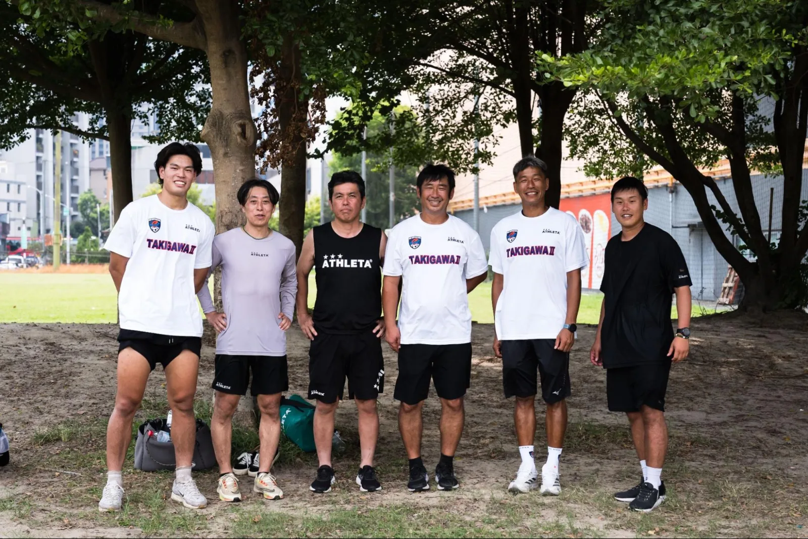 滝川第二的教練與工作人員在樹下合影