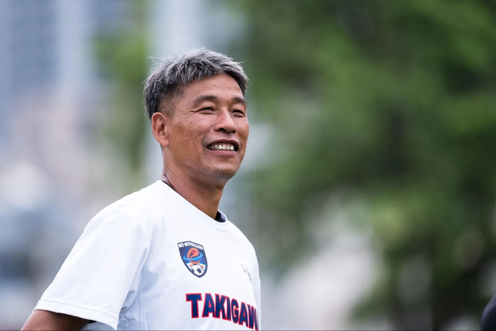 身穿滝川第二上衣的教練露出笑容